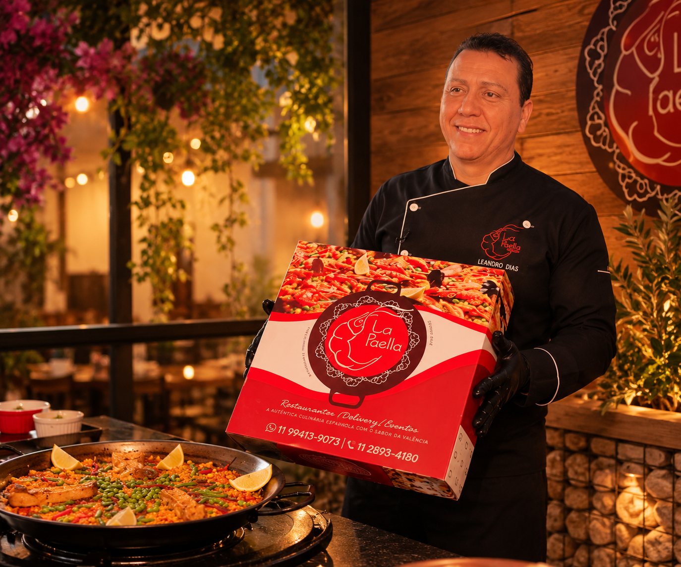 Chef Leandro Dias apresentando a caixa de delivery do La Paella no salão do restaurante